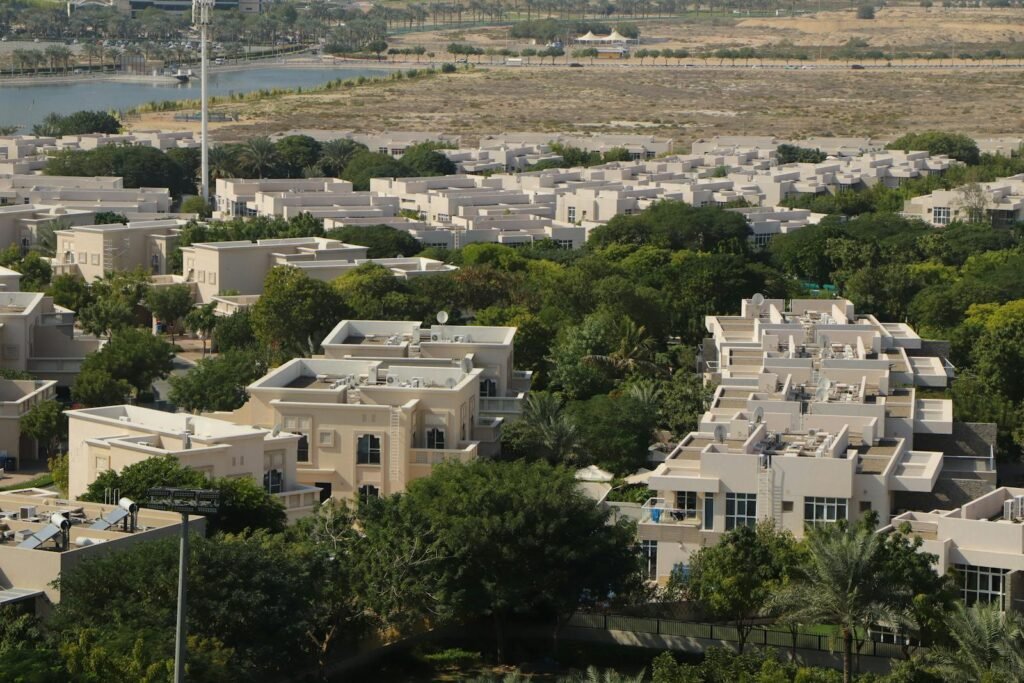 An expansive aerial view of a residential community surrounded by greenery in Dubai, UAE.