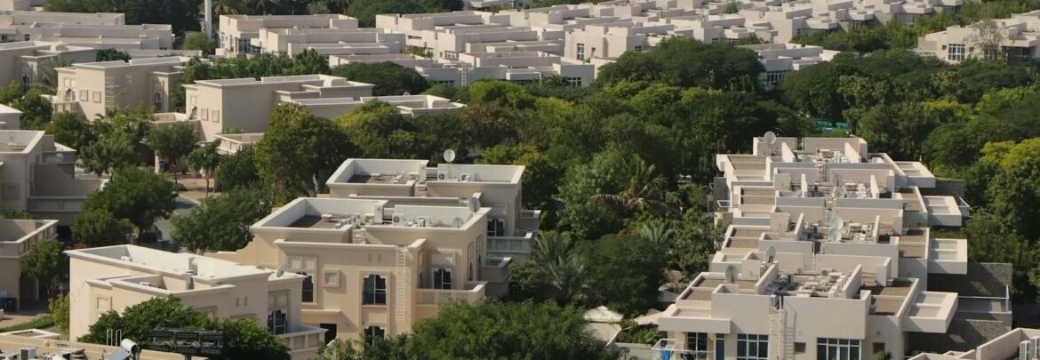 An expansive aerial view of a residential community surrounded by greenery in Dubai, UAE.