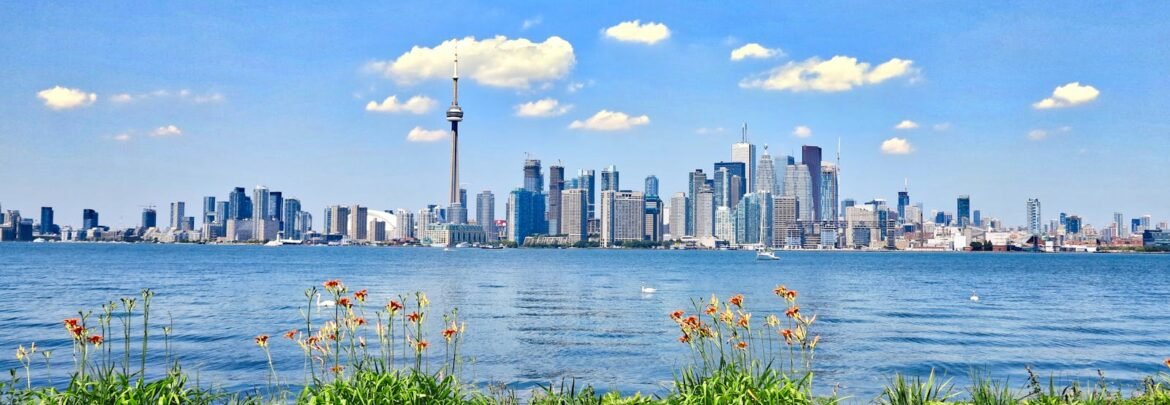 Scenic view of Toronto skyline with CN Tower against a clear blue sky, seen from across the waterfront.