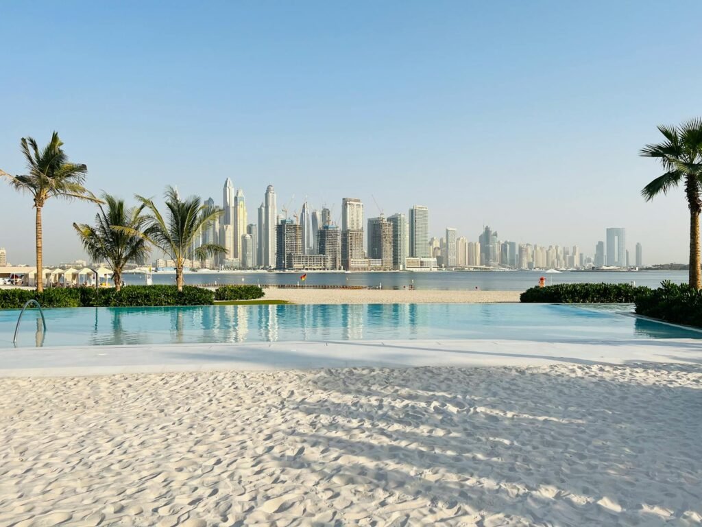 Luxurious beachfront pool overlooking the iconic Dubai skyline on a sunny day.