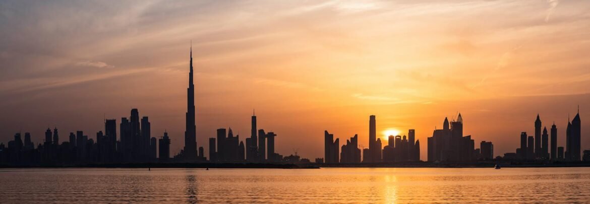 Enchanting view of Dubai's skyscrapers at sunset with the iconic Burj Khalifa outlined against the vivid sky.