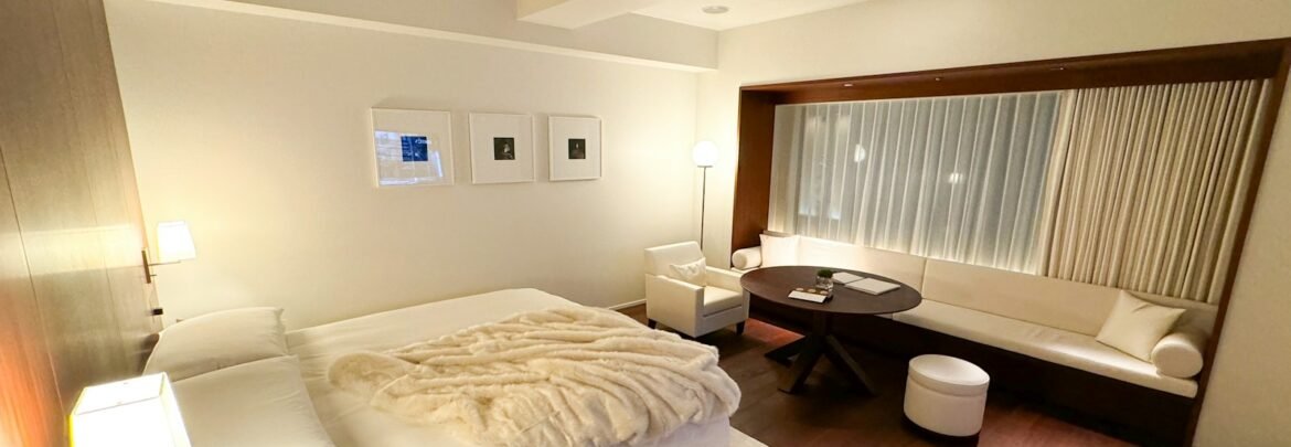 A bedroom with a large bed and wooden floors