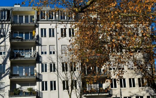 A tall white building with balconies and balconies
