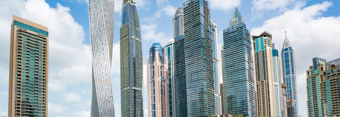 white and blue boat on sea near city buildings during daytime