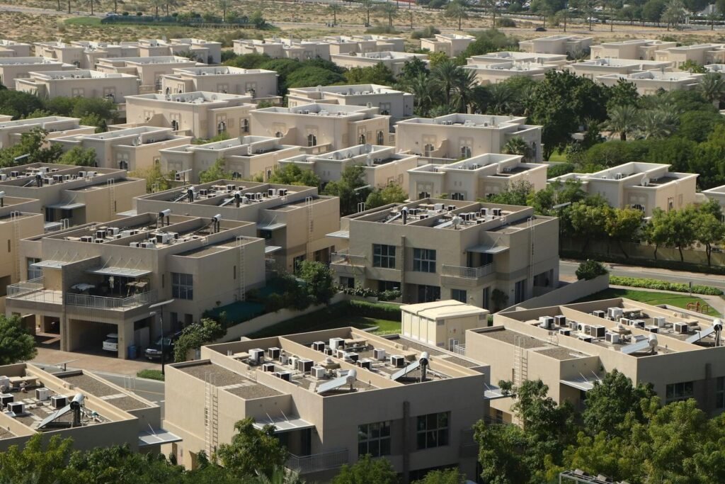 Aerial view of modern residential villas surrounded by greenery in Dubai.