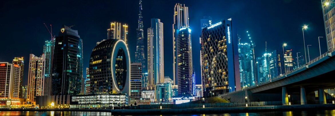 High-rise buildings of Dubai glittering at night, with Burj Khalifa illuminated in the skyline.
