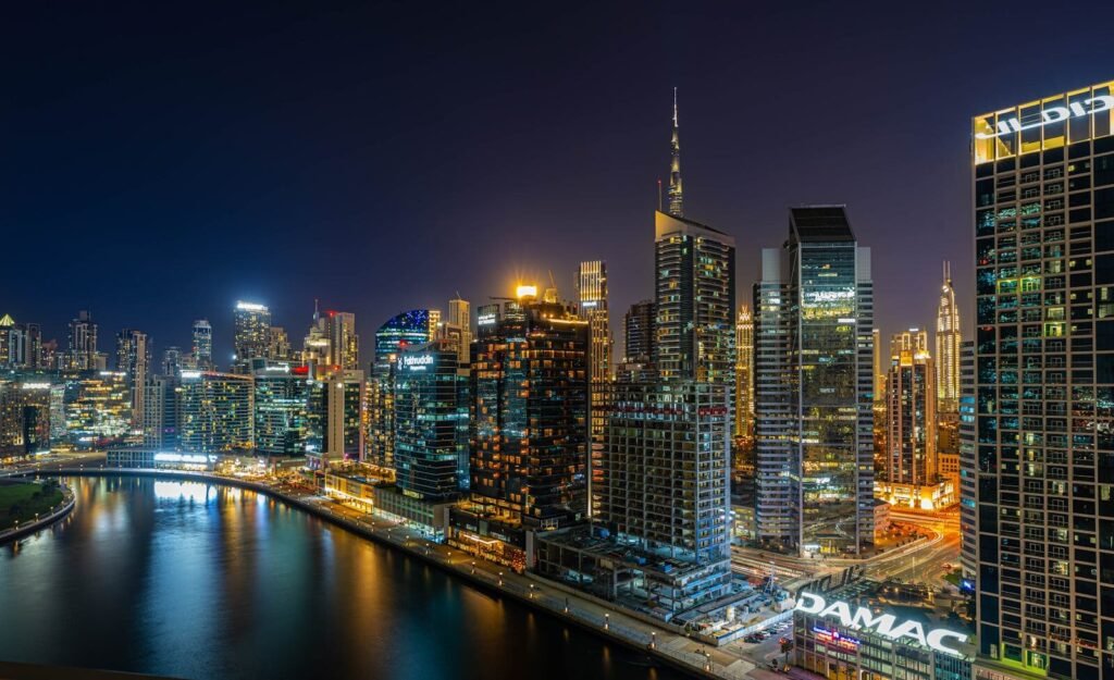 Stunning aerial view of Dubai's illuminated skyline at night, featuring modern skyscrapers along the water.