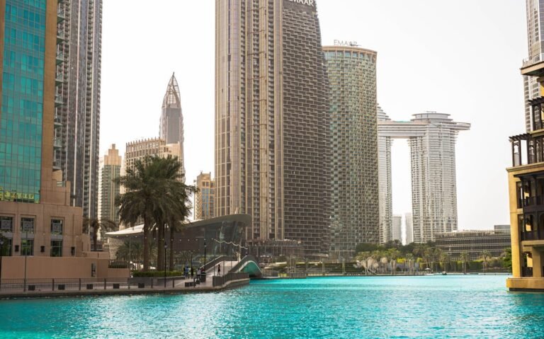 Stunning view of Dubai's modern skyline and vibrant blue water under a clear sky.