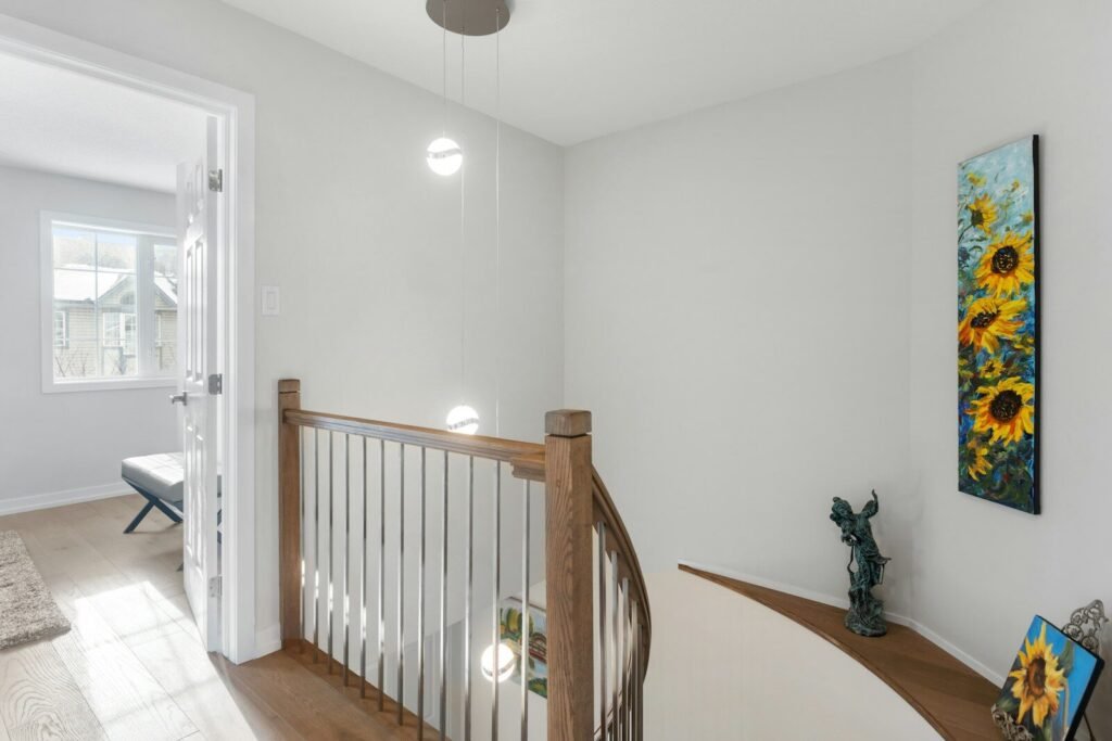 a hallway with a staircase and a painting on the wall