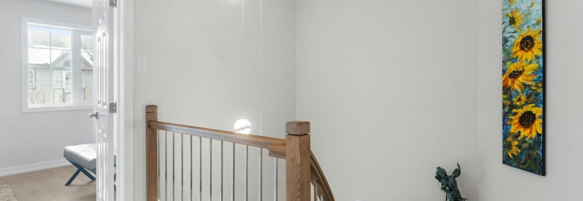 a hallway with a staircase and a painting on the wall