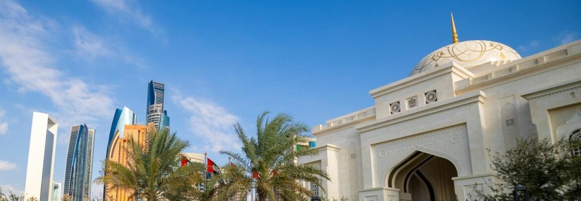 A breathtaking view of Abu Dhabi's skyline with a stunning mosque in the foreground under a clear blue sky.