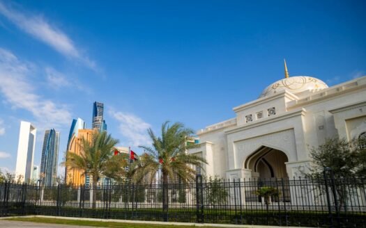 A breathtaking view of Abu Dhabi's skyline with a stunning mosque in the foreground under a clear blue sky.