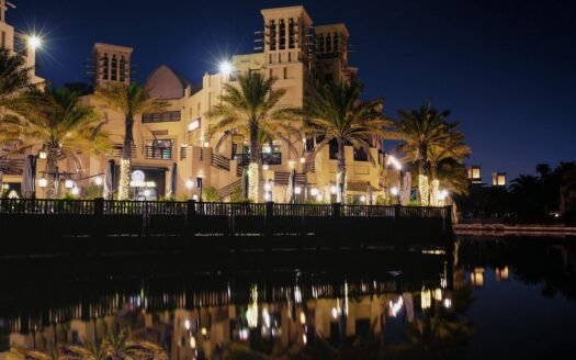 Elegant Dubai architecture reflected in a waterfront setting at night.