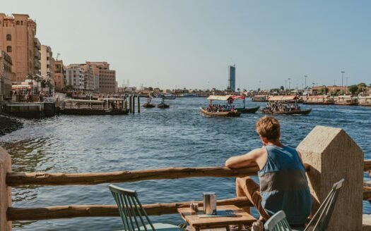 A man sitting at a table looking out over the water