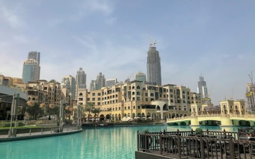 white and blue boat on water near city buildings during daytime