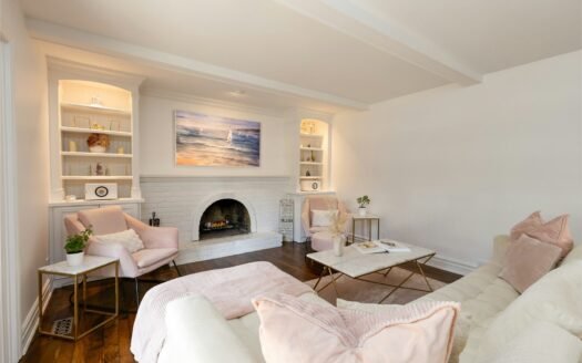 A cozy living room with white walls and fireplace.