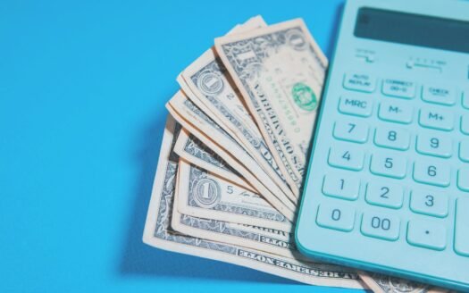 Us dollar bills and a calculator on blue background